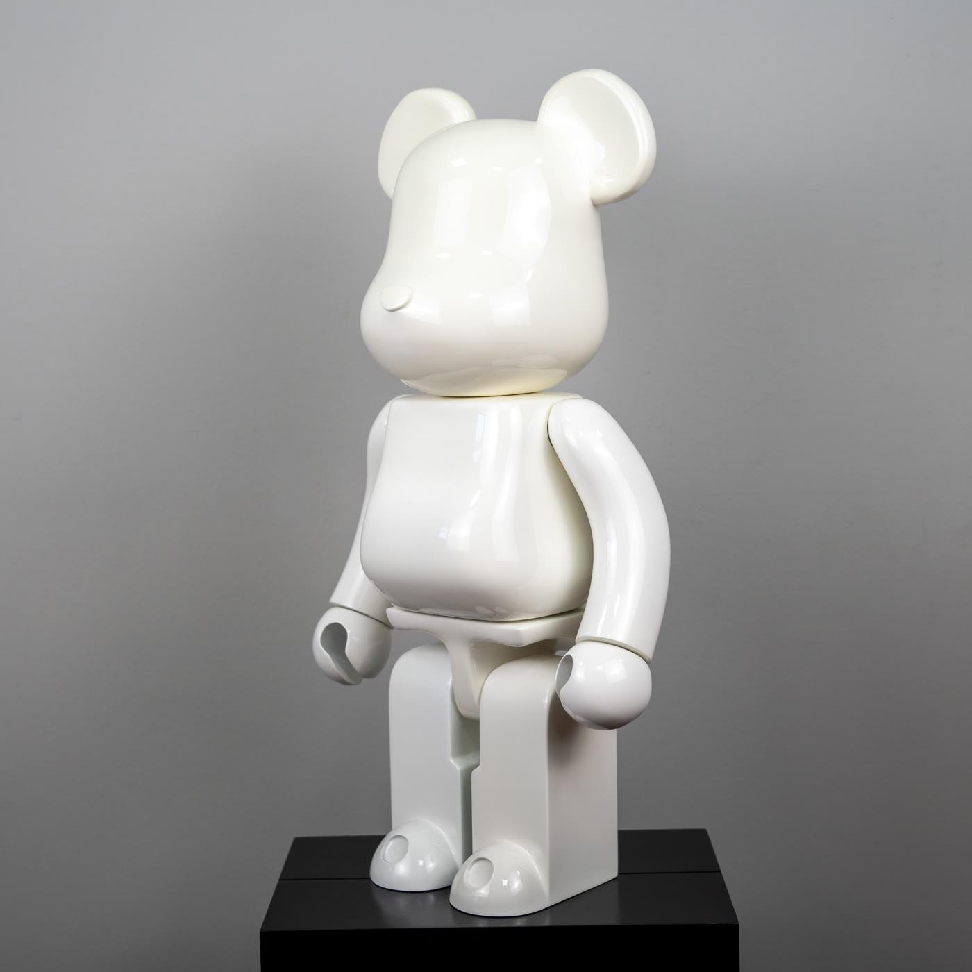 Parlak beyaz Bearbrick, sade stüdyo fonunda