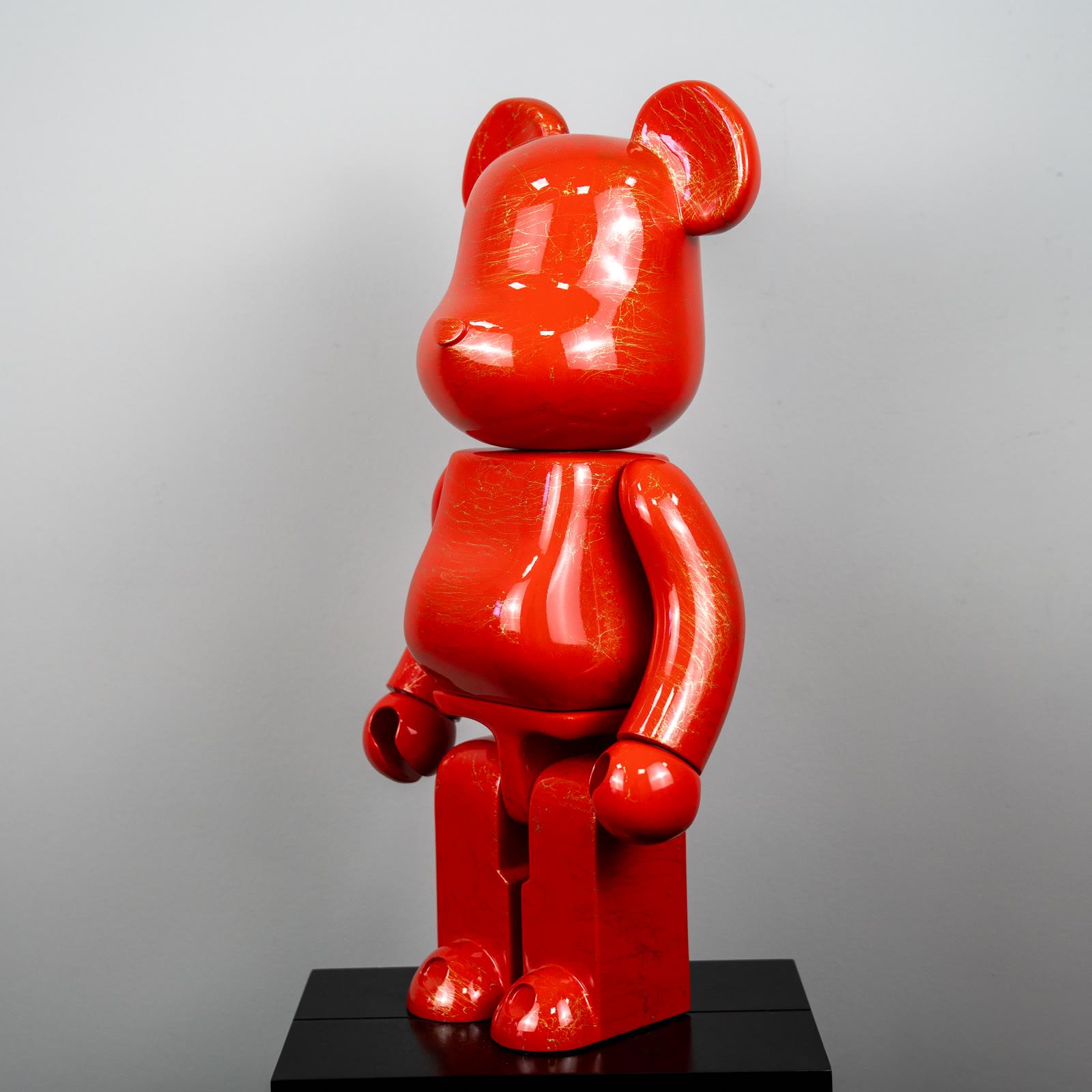 Parlak kırmızı Bearbrick, altın mermer desenli yüzey